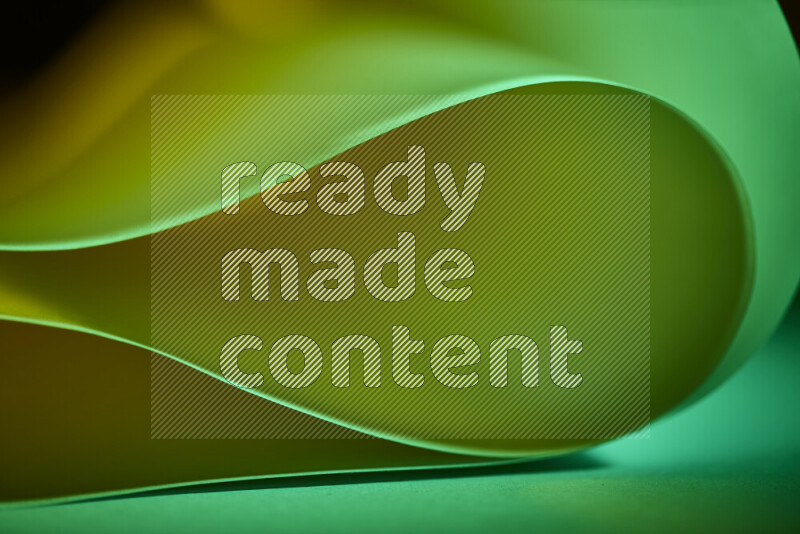 An abstract art piece displaying smooth curves in green gradients created by colored light