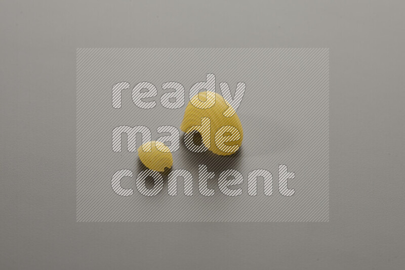 Shells pasta with other types of pasta on grey background