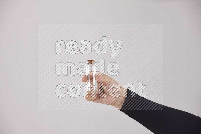 A woman in black abaya holding different glassware in different positions