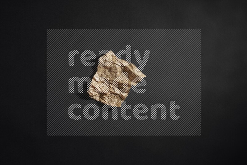 Crumpled craft paper on black background