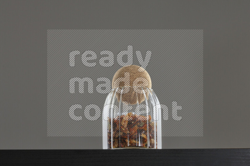 Chili pepper in a glass jar on black background