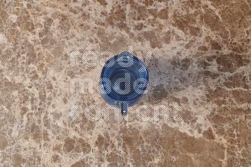 A colored glass jug on beige marble background