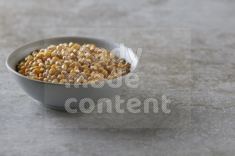 corn kernel in a gray ceramic bowl on a grey textured countertop
