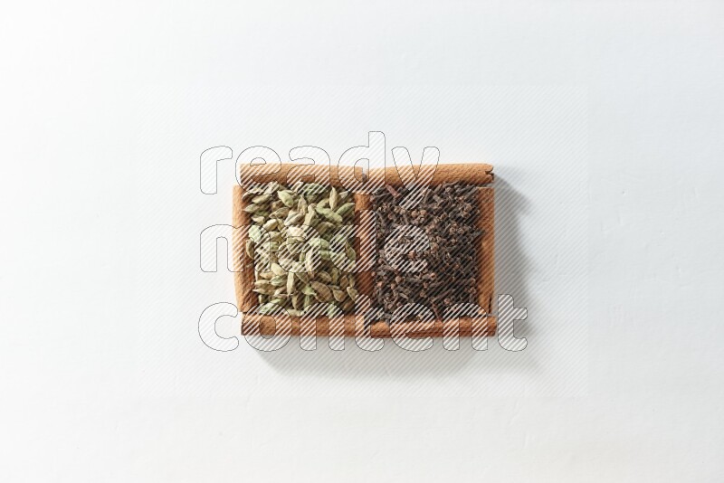 2 squares of cinnamon sticks full of cloves and cardamom on white flooring