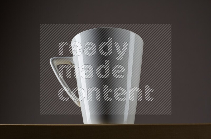Low angle shot of a white cup on grey background