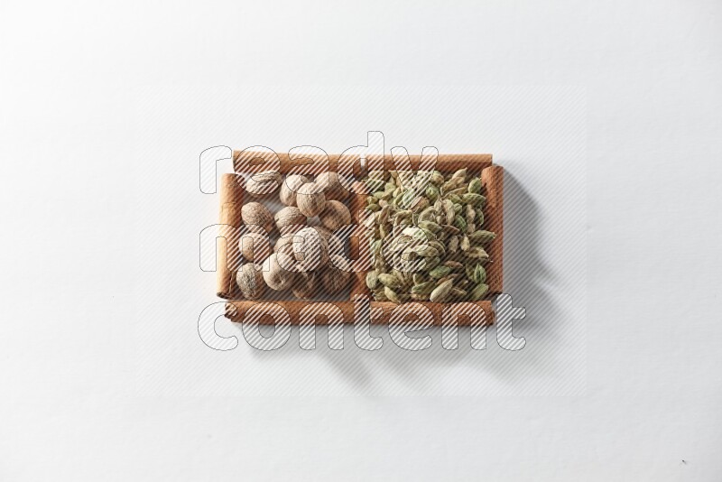 2 squares of cinnamon sticks full of cardamom and nutmegs on white flooring