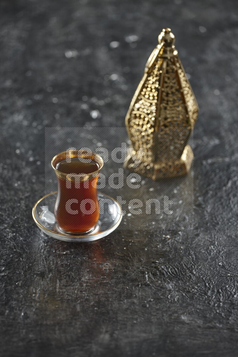 A golden lantern with different drinks, dates, nuts, prayer beads and quran on textured black background