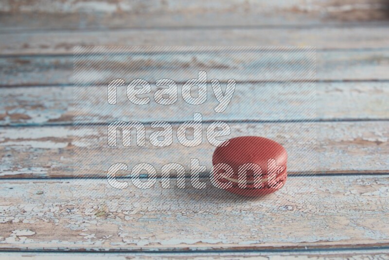 45º Shot of Red Velvet macaron on light blue wooden background