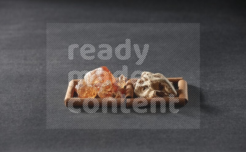 2 squares of cinnamon sticks full of dried ginger and gum arabic on black flooring