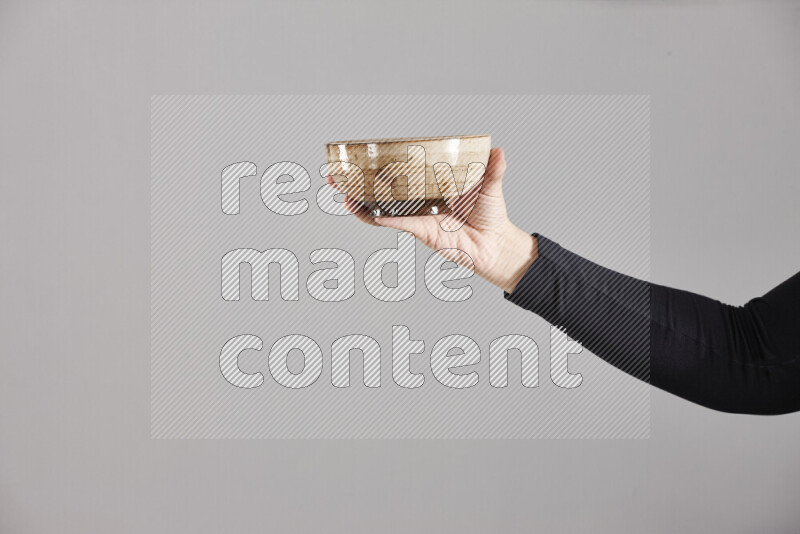 A woman in black abaya holding different pottery essentials in different positions