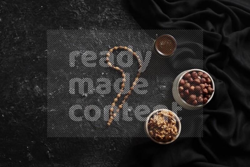 Nuts in pottery bowls with coffee in a dark setup