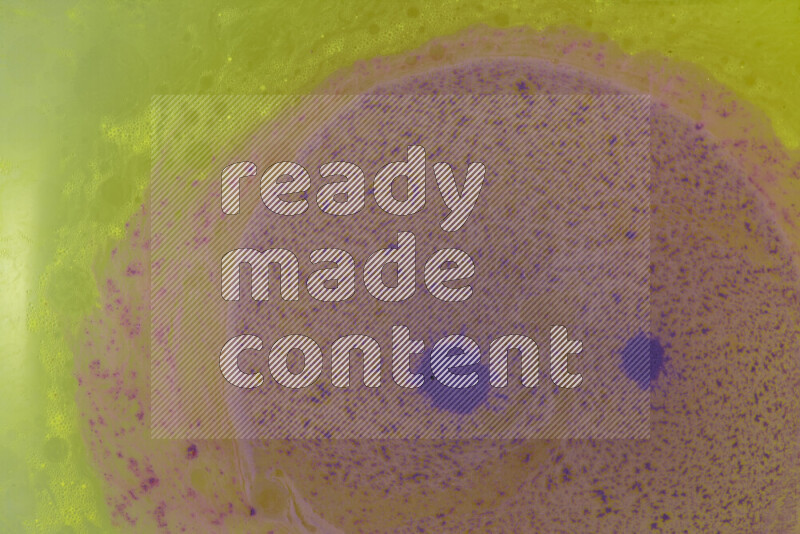 The image captures a dramatic splatter of purple paint over a yellow backdrop