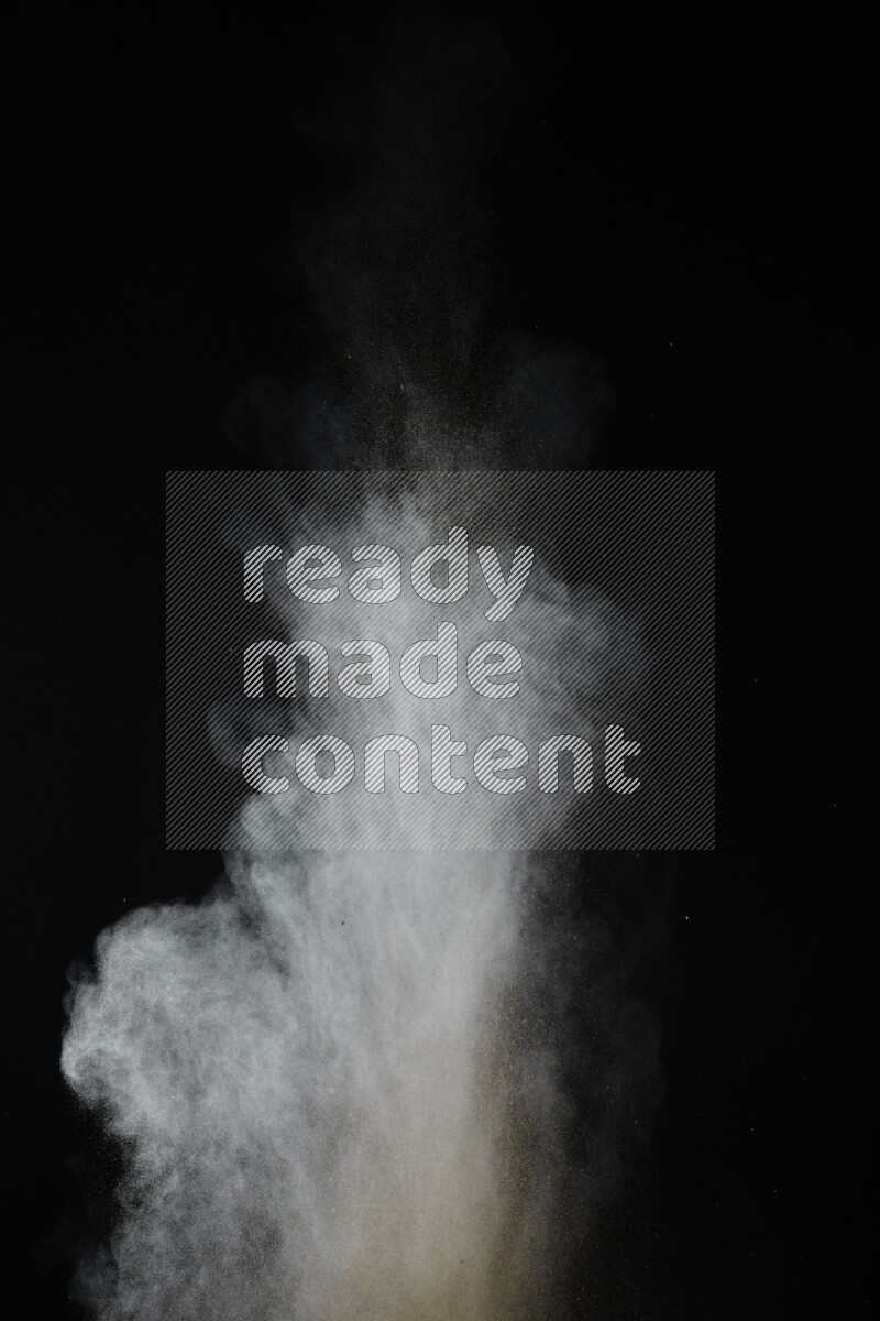 A side view of brown powder explosion on black background