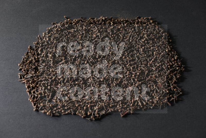 Cloves spread on black flooring