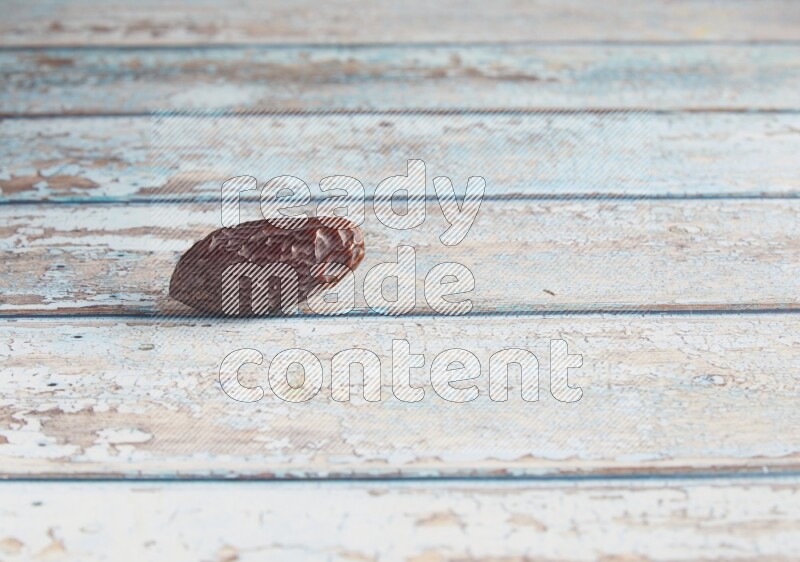 one madjoul date on a light blue wooden background