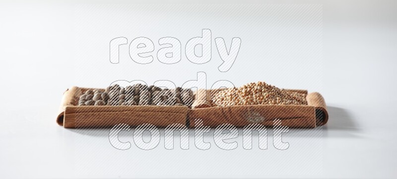 2 squares of cinnamon sticks full of mustard seeds and allspice on white flooring