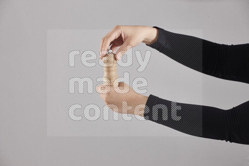 A woman in black abaya holding different wooden essentials in different positions