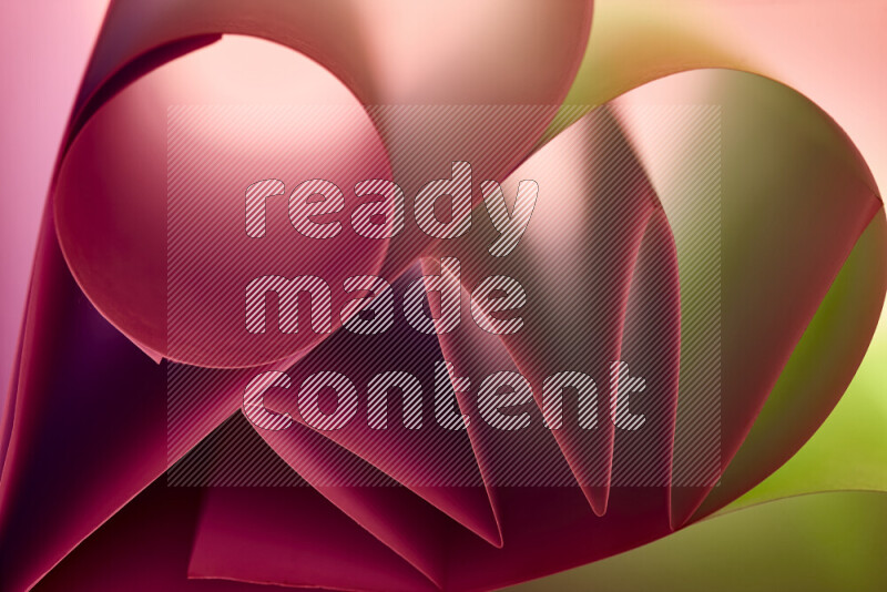 An artistic display of paper folds creating a harmonious blend of geometric shapes, highlighted by soft lighting in green and red tones