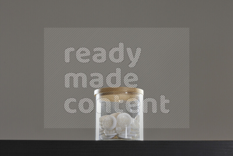 Buttons in a glass jar on black background