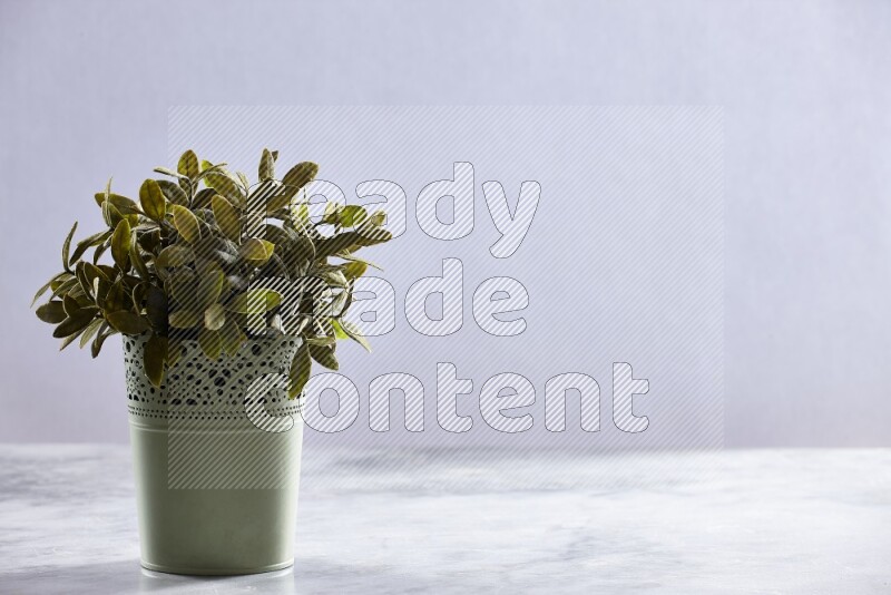 Artificial plant in green decorative pot on grey marble background