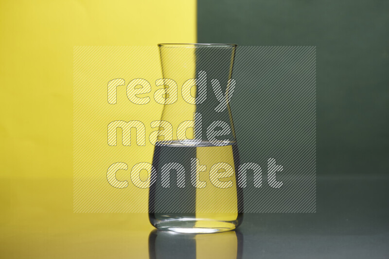 The image features a clear glassware filled with water, set against yellow and dark green background