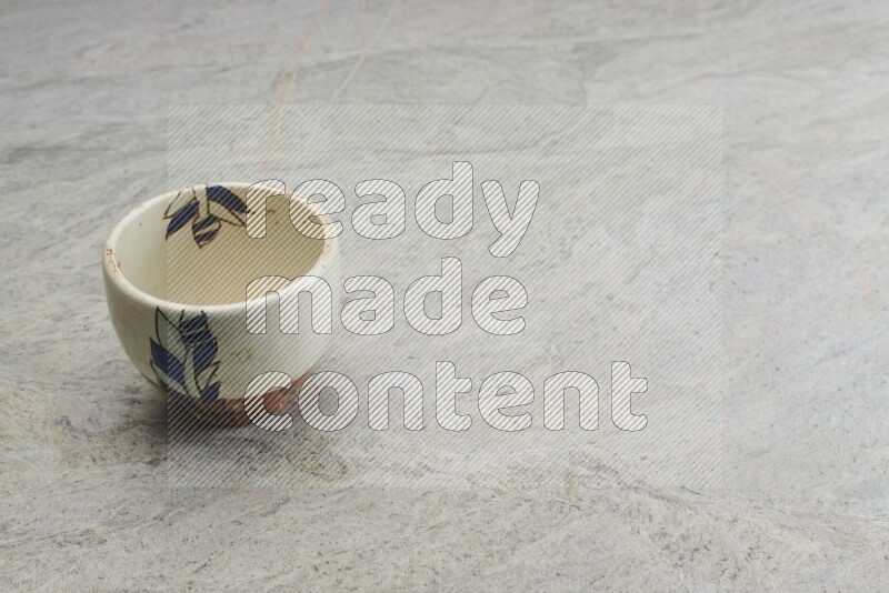 A multicolored pottery bowl on grey marble background