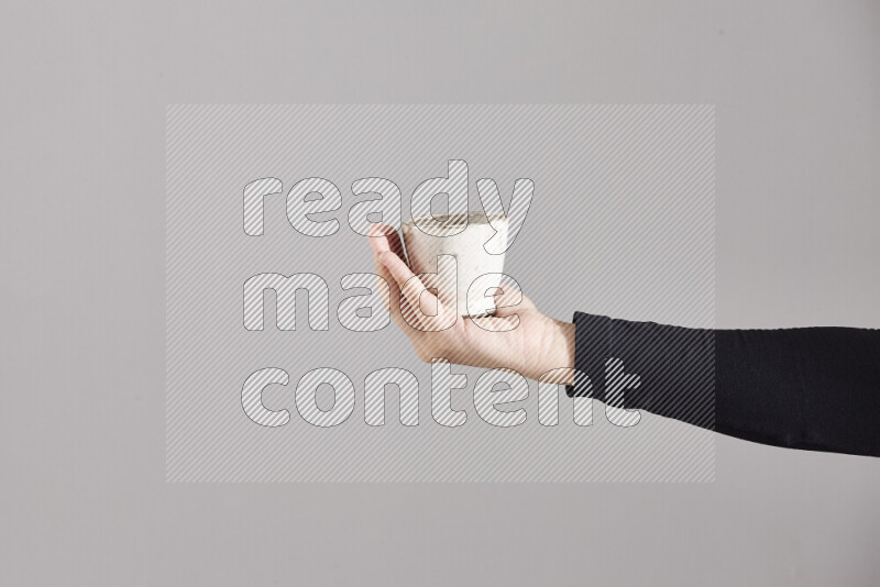 A woman in black abaya holding different pottery essentials in different positions