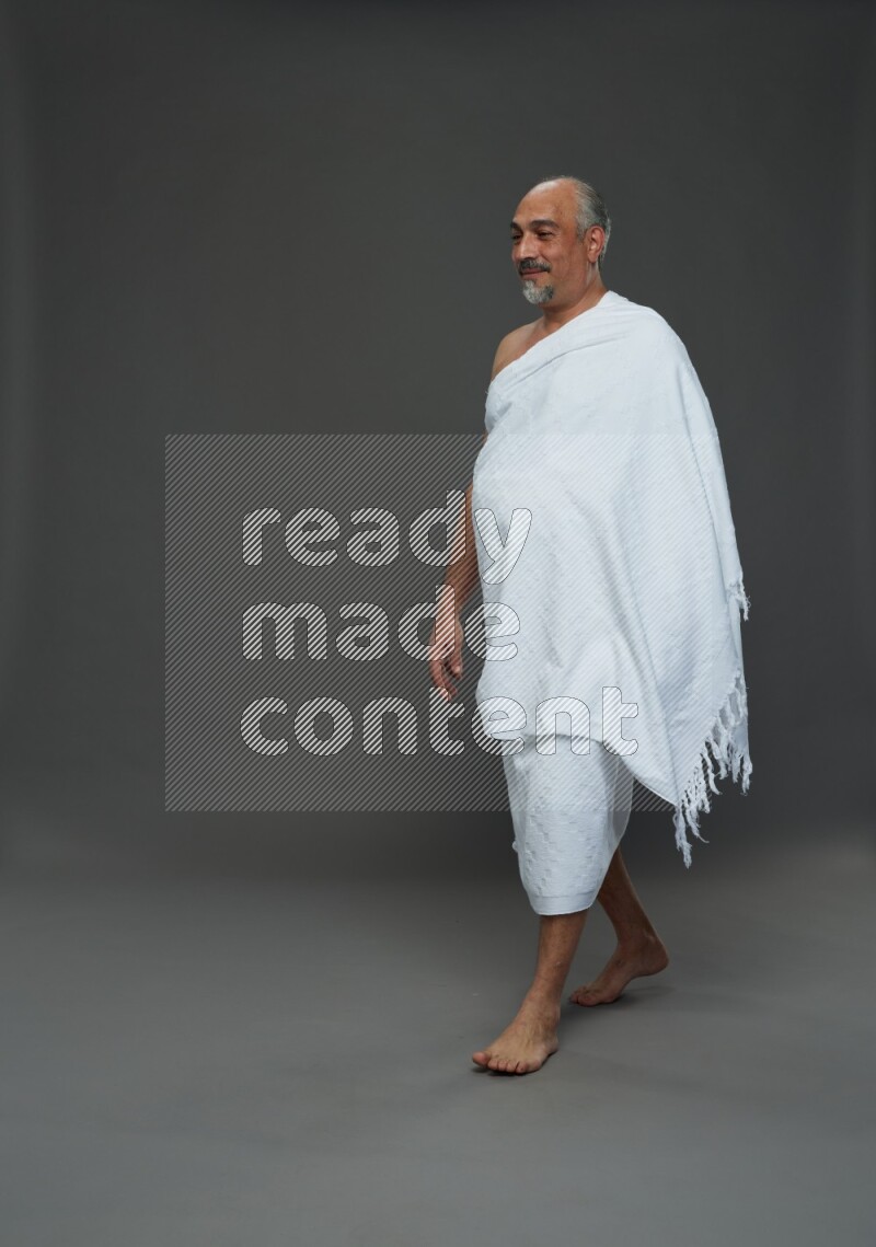 A man wearing Ehram Standing Interacting with the camera on gray background