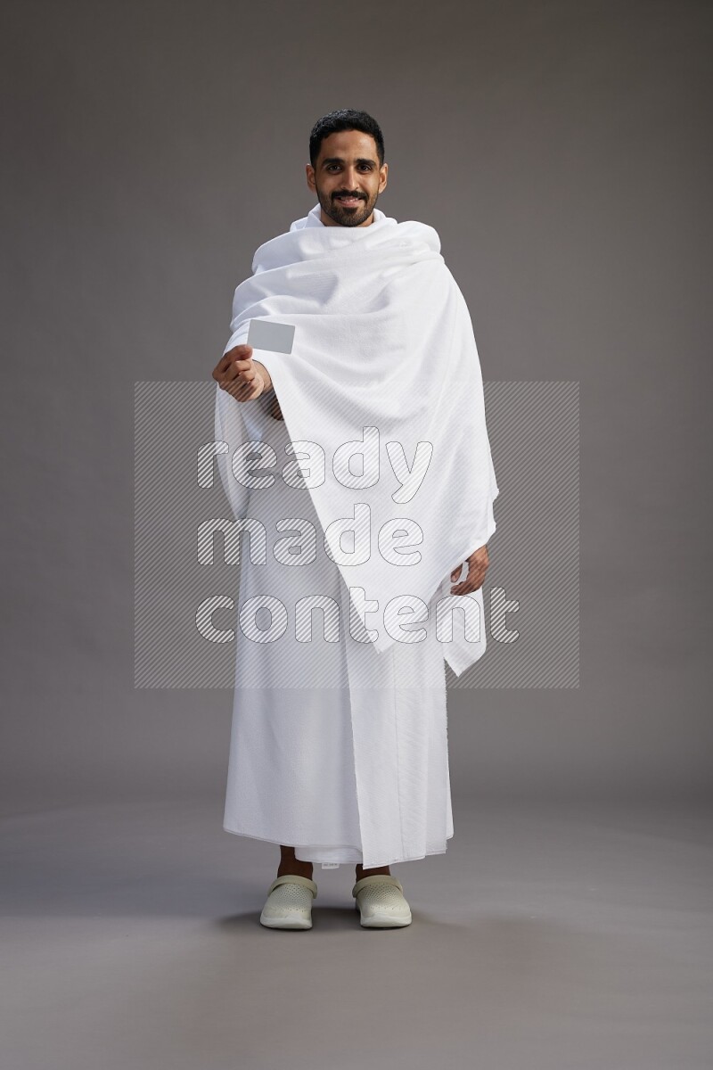 A man wearing Ehram Standing holding ATM card on gray background