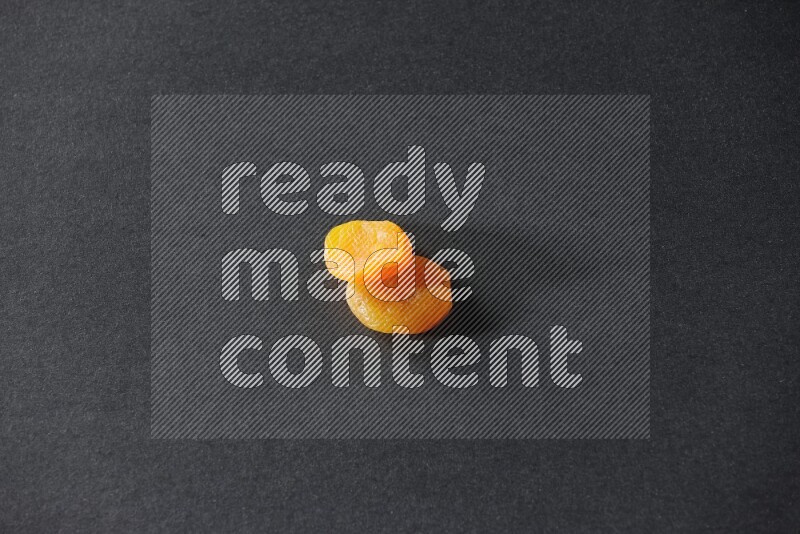 Two dried apricots on a black background in different angles
