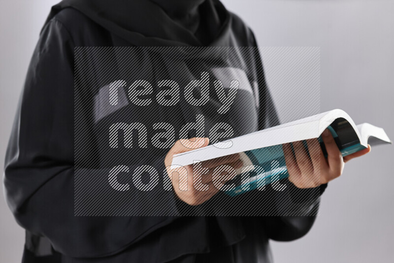 A woman in abaya holding books and a board in different positions (back to school)