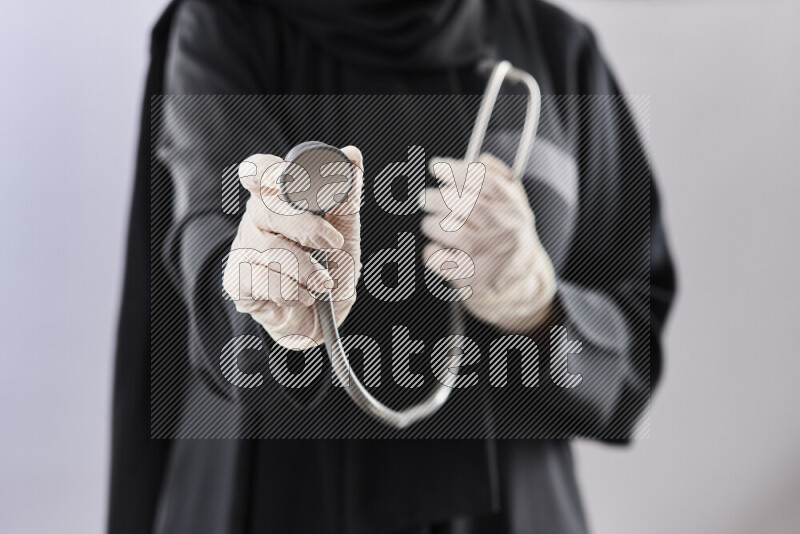 Female doctor wearing an abaya and medical attire in different positions
