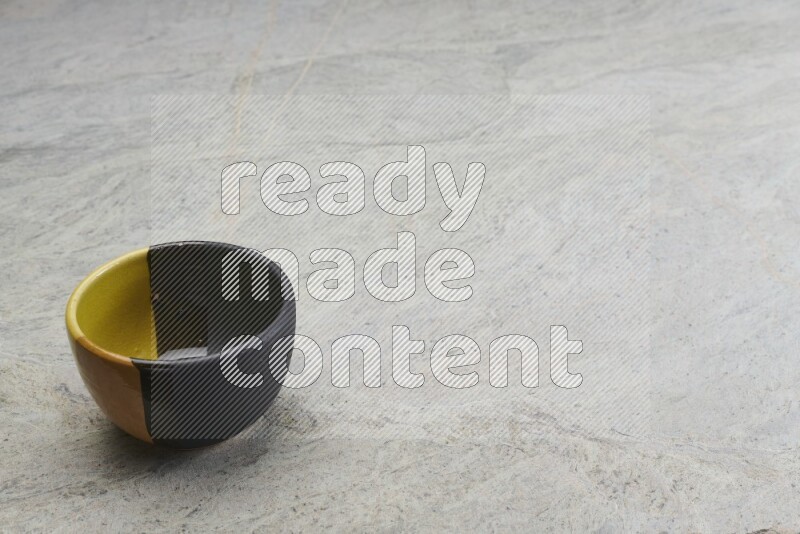 A multicolored pottery bowl on grey marble background