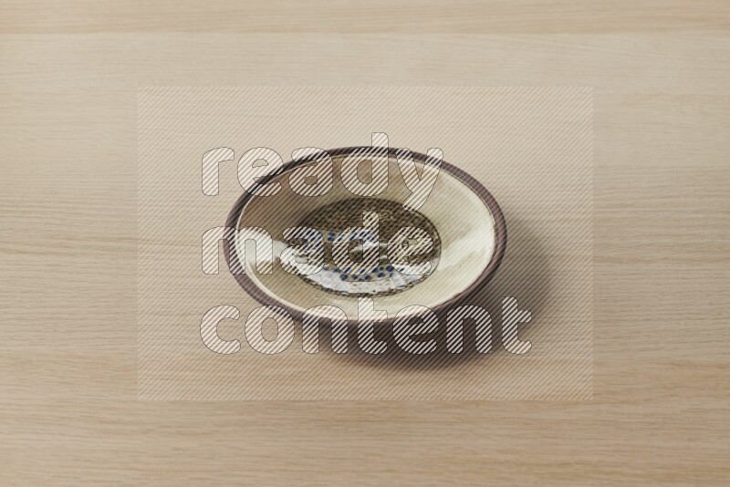 A decorative pottery plate on light wooden background