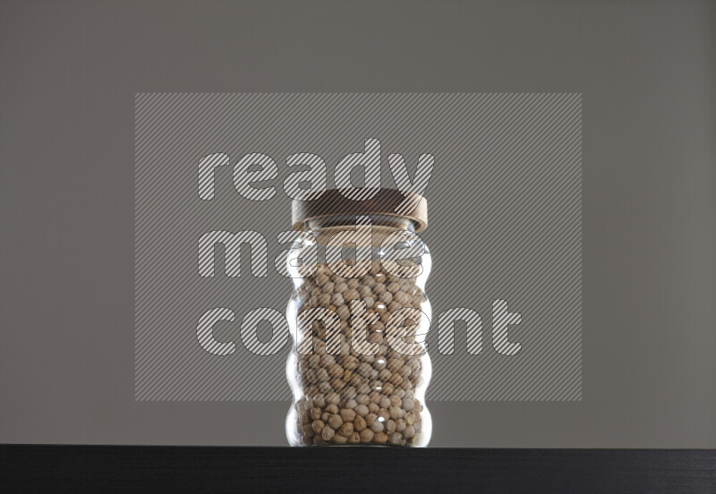 Chickpeas in a glass jar on black background