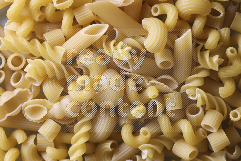 Different pasta types on light blue background
