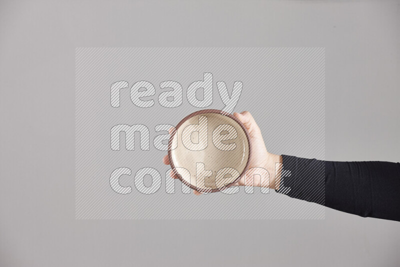 A woman in black abaya holding different pottery essentials in different positions