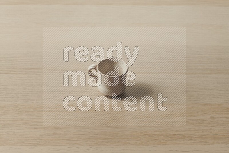 A pottery cup on light wooden background