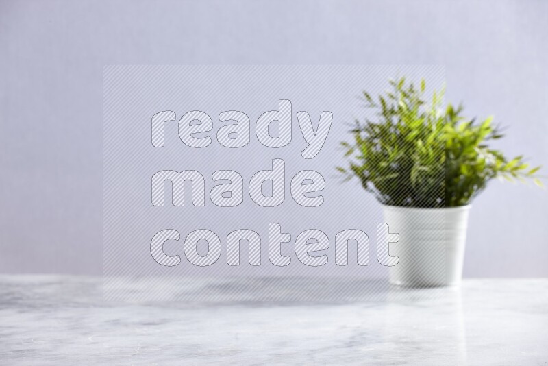 Artificial plant in white pot on grey marble background