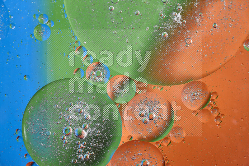 Close-ups of abstract oil bubbles on water surface in shades of orange, green and blue