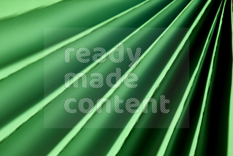 An image presenting an abstract paper pattern of lines in green tones
