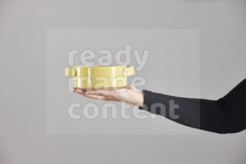 A woman in black abaya holding different pottery essentials in different positions