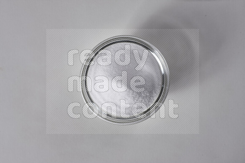 A glass bowl full of fine table salt on white background