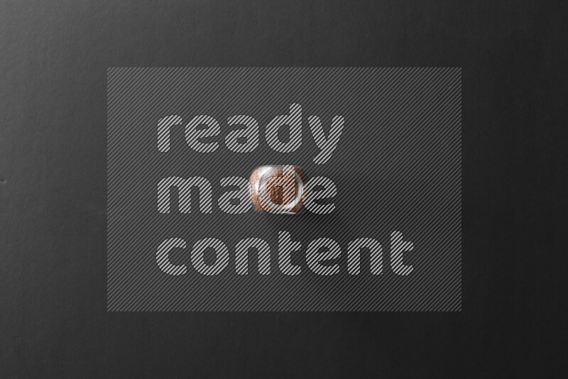 A glass spice jar full of flax on black flooring