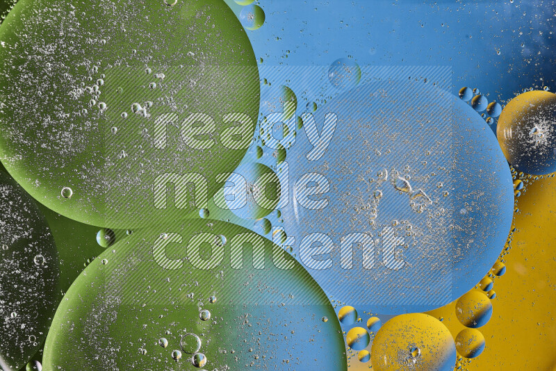 Close-ups of abstract oil bubbles on water surface in shades of yellow, green and blue