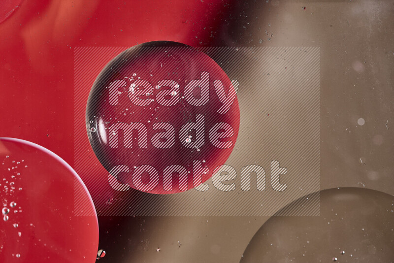 لقطات مقربة لفقاعات من الزيت على سطح الماء باللون الأحمر والبني