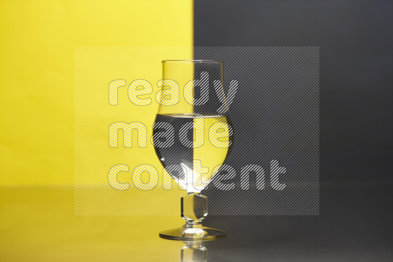 The image features a clear glassware filled with water, set against yellow and black background