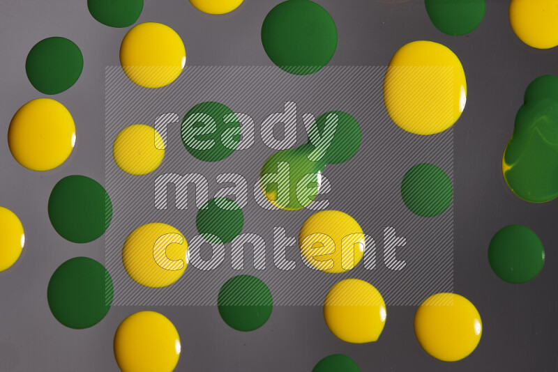 لقطات مقربة لقطرات من اللون الأصفر والأخضر على الخلفية