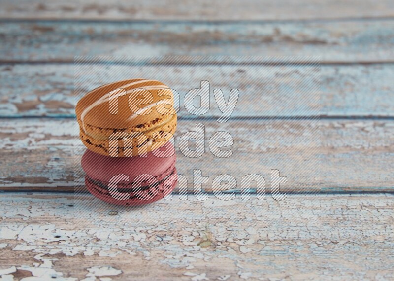 45º Shot of of two assorted Brown Irish Cream, and Red Cherry macarons  on light blue background