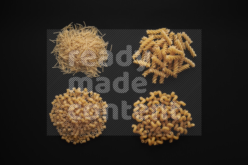 Different pasta types in bunches on black background